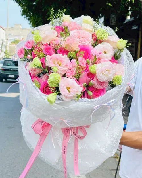 Bó hoa hồng sinh nhật tươi thắm phối sắc hồng và trắng nhẹ nhàng, bọc trong giấy gói trắng trang nhã thắt nơ hồng điệu đà, mang vẻ đẹp ngọt ngào